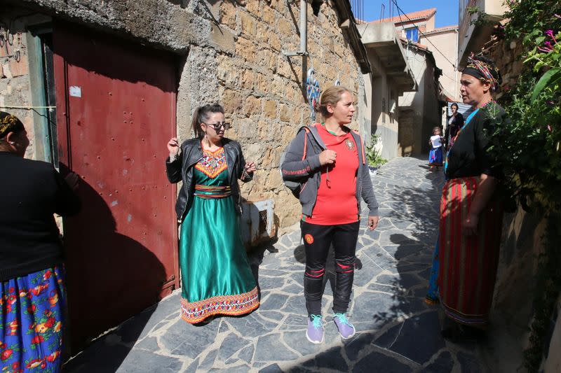 Aida, 41, wears her sports outfit speaks to her neighbours in the village of Sahel