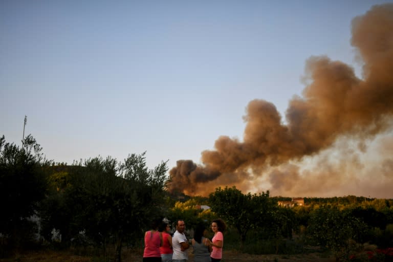 People watch the progression of a wildfire in Macao, central Portugal, on July 26, 2017