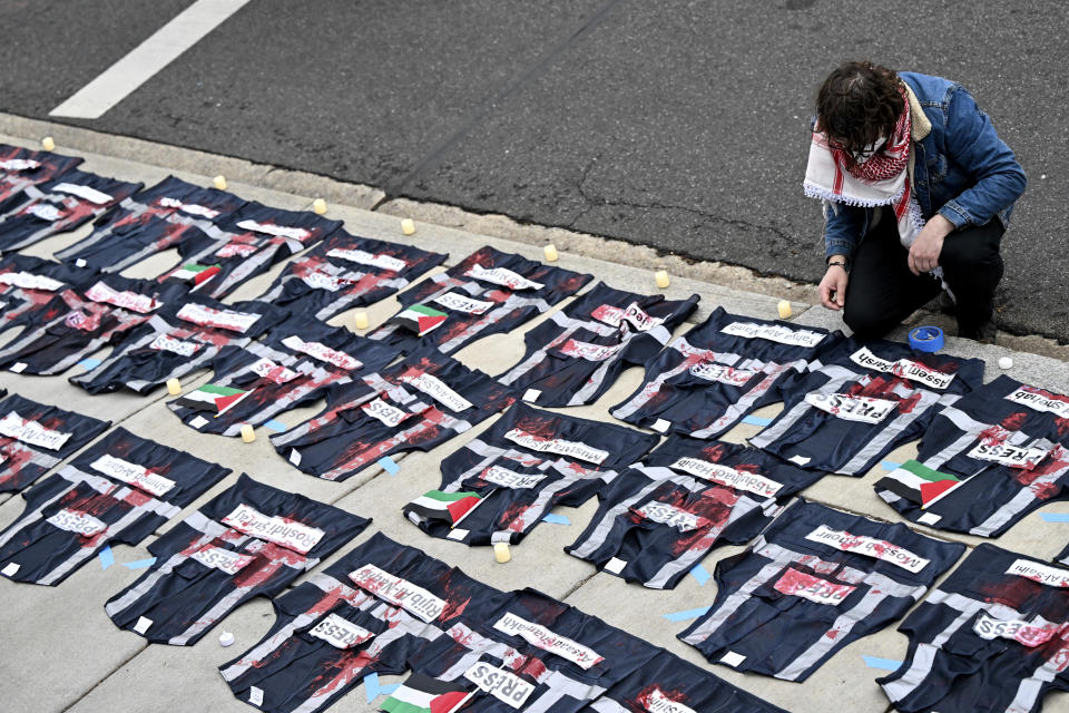 A demonstrator lays candles on the ground next to press vest covered in red paint during a pro-Palestinian protest over the Israel-Hamas war at the White House Correspondents' Association Dinner at the Washington Hilton, Saturday April 27, 2024, in Washington. (AP Photo/Terrance Williams)