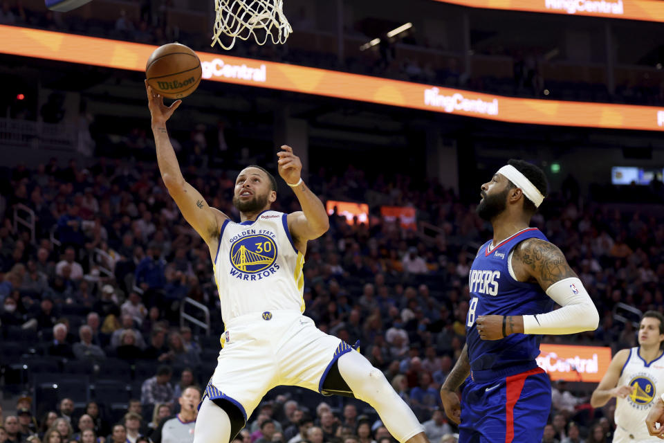 Golden State Warriors guard Stephen Curry (30) shoots against Los Angeles Clippers forward Marcus Morris Sr. (8) during the first half of an NBA basketball game in San Francisco, Tuesday, March 8, 2022. (AP Photo/Jed Jacobsohn)