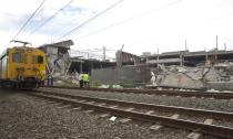 A commuter train moves past a building that collapsed in the South African town of Tongaat, about 45 km (28 miles) north of Durban, November 20, 2013. Rescue workers with sniffer dogs picked through rubble in search of survivors on Wednesday after a soccer pitch-sized section of the half-built mall collapsed, killing at least one and injuring dozens. It was not immediately clear how many people might be still trapped in the wreckage after the three-storey building collapsed on Tuesday afternoon. Apart from one confirmed death, 29 people, two of them in critical condition, were rushed to nearby hospitals, which initiated full-scale disaster plans, health officials said. REUTERS/Rogan Ward (SOUTH AFRICADISASTER - Tags: DISASTER TRANSPORT)