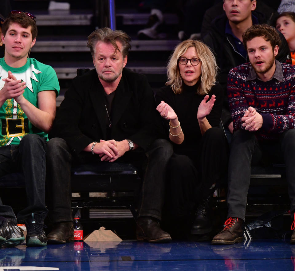 John Mellencamp with family at a basketball game, sitting courtside engaged in conversation