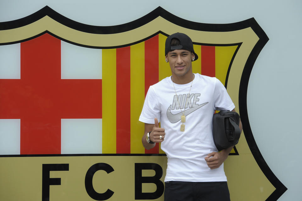 FILE - In this June 3, 2013 file photo, FC Barcelona's then new signing Neymar gestures upon his arrival at the club's office at the Camp Nou stadium in Barcelona, Spain. A Spanish court has charged Spanish league champion Barcelona with tax fraud of euro 9.1 million ($12.5 million) over the transfer of Brazil forward Neymar. Judge Pablo Ruz said in his decision, released on Thursday, Feb. 20, 2014 there was enough evidence to merit charges over Neymar's 57 million-euro (then $77 million) move from Santos last summer. Thursday's decision comes a day after public prosecutor Jose Perals charged Barcelona with fabricating simulated contracts and using "financial engineering" to defraud the Spanish Treasury. Barcelona has denied the charges. (AP Photo/Manu Fernandez, File)