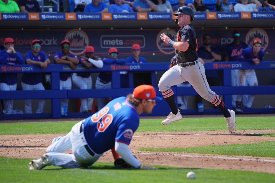 Detroit Tigers second baseman Jace Jung (84) scores a run on a throwing error on by New York Mets right fielder Trayce Thompson as first baseman Luke Voit (99) tries to locate the ball in the eighth inning at Clover Park on March 10, 2024, in Port St. Lucie, Fla.