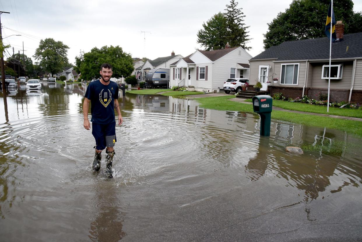 Tad Burkey of Monroe walks down Parkwood Street where his home's basement flooded in August 2023.