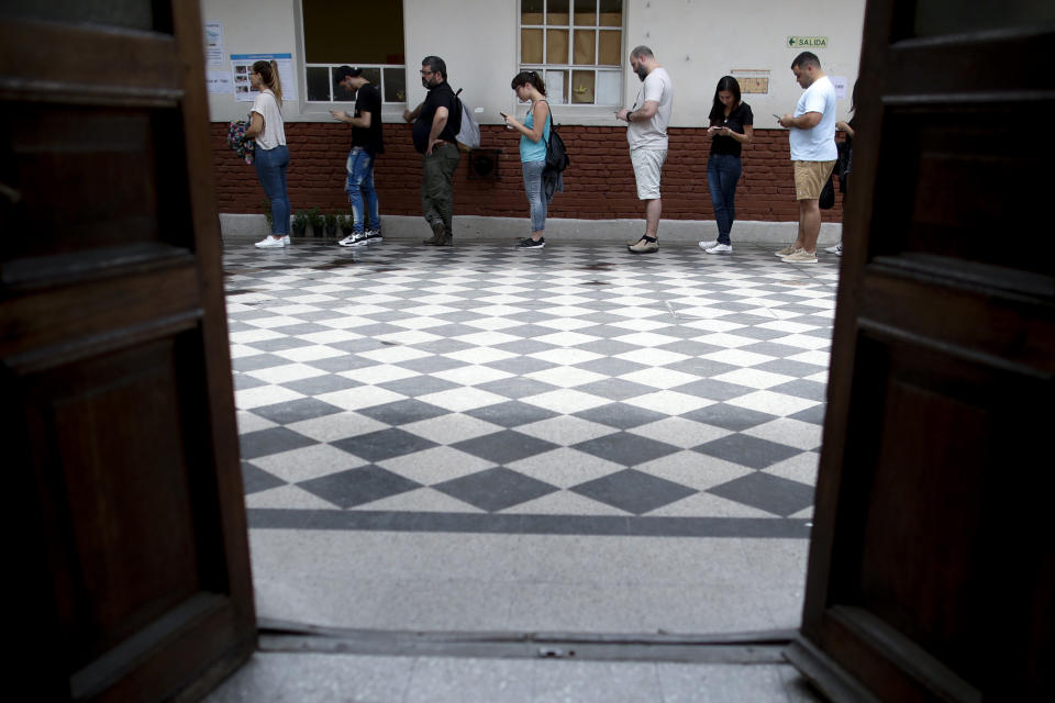 Voters line up in Buenos Aires, Argentina, Sunday, Oct. 27, 2019. Argentina could take a political turn in Sunday's presidential elections, with center-left Peronist candidate Alberto Fernandez favored to oust Mauricio Macri amid growing frustration over the country's economic crisis. (AP Photo/Natacha Pisarenko)