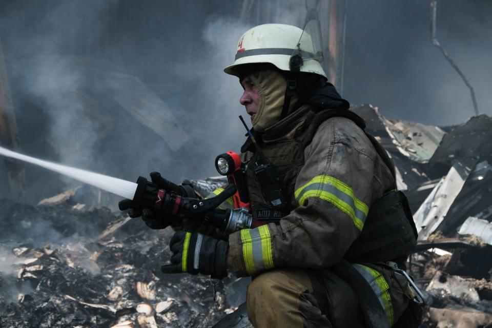 Ukrainian first responder works at the site of a Russian missile attack on a publishing factory in Kharkiv, Ukraine on May 23, 2024. (Francis Farrell/The Kyiv Independent)