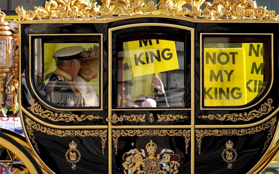 The state coach carrying the King and Queen passes by protesters from anti-monarchy pressure group Republic at the last State Opening of Parliament (PA Archive)