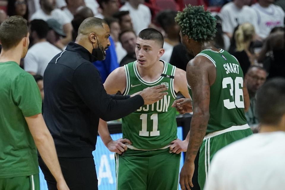 Boston Celtics head coach Ime Udoka talks to guards Payton Pritchard (11) and Marcus Smart (36) during a time out during in the first half of Game 2 of the NBA basketball Eastern Conference finals playoff series against the Miami Heat, Thursday, May 19, 2022, in Miami. (AP Photo/Lynne Sladky)