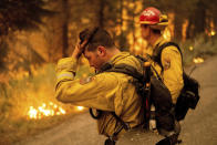 Firefighter Jesse Forbes rubs his head while battling the Dixie Fire near Prattville in Plumas County, Calif., on Friday, July 23, 2021. (AP Photo/Noah Berger)