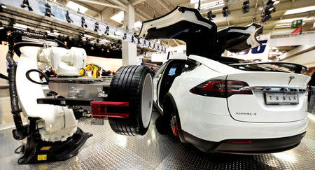 A robotic arm changes the tyre of a Tesla car at the world's biggest industrial fair, "Hannover Fair", in Hanover, Germany April 24, 2017. REUTERS/Fabian Bimmer