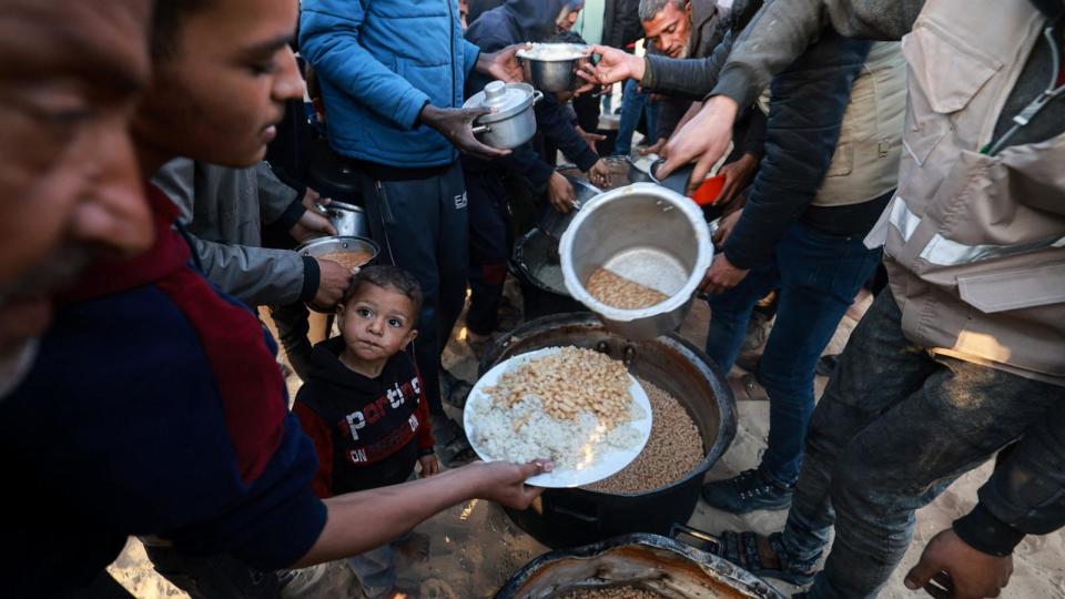 PHOTO: Displaced Palestinians collect food donated by a charity before an iftar meal, the breaking of fast, on the first day of the Muslim holy fasting month of Ramadan, in Rafah in the southern Gaza Strip, Mar. 11, 2024. (Mohammed Abed/AFP via Getty Images)