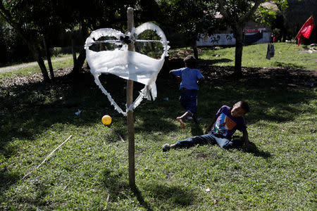 FILE PHOTO: Children play soccer near a heart-shaped sign with the name of Jakelin, a 7-year-old girl who died in U.S. custody, outside her house in San Antonio Secortez, municipality of Raxruha, Guatemala December 19, 2018. REUTERS/Luis Echeverria/File Photo