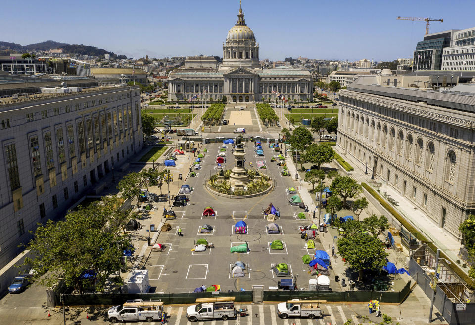 FILE - In this May 21, 2020, file photo, rectangles designed to help prevent the spread of the coronavirus by encouraging social distancing line a city-sanctioned homeless encampment at San Francisco's Civic Center. California has spent $13 billion in the last three years to tackle a massive homelessness problem likely to worsen with the pandemic, yet its approach is so disjointed and incomplete as to hinder efforts at getting people into stable housing, the state auditor said in a report released Thursday, Feb. 11, 2021. (AP Photo/Noah Berger, File)