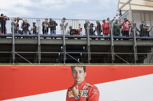 Spectators stand over a poster of Ferrari driver Charles Leclerc before the Monaco Grand Prix 