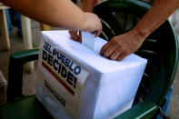 <p>People cast their votes during an unofficial plebiscite against Venezuela’s President Nicolas Maduro’s government and his plan to rewrite the constitution, in Caracas, Venezuela July 16, 2017. The writing on the box reads “The people decide, Liberator Movement.” (Marco Bello/Reuters) </p>