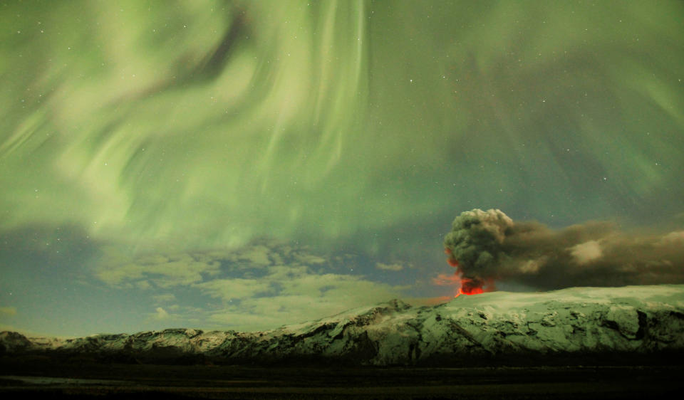 La Luces del Norte contrastan con el humo que sale del volcán Eyjafjallajokull en Islandia, el 22 de abril de 2010. Este acontecimiento provocó la cancelación de miles de vuelos. (REUTERS/Lucas Jackson)