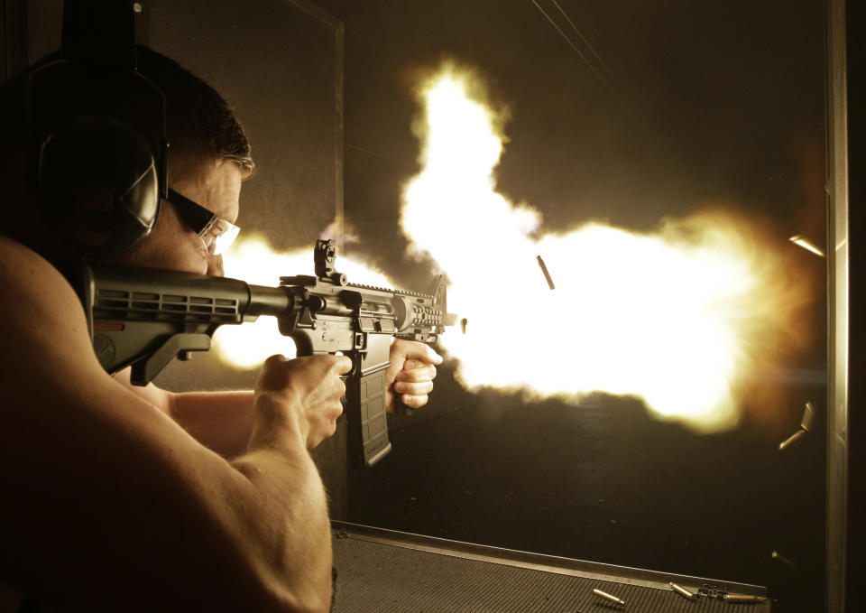 FILE - In this Thursday, Aug. 28, 2014, file photo, Simon Winson of Manchester, England fires a fully automatic machine gun at Machine Guns Vegas in Las Vegas. Strict gun laws keep the real guns out of reach for most people, especially outside the U.S., indoor shooting ranges with high-powered weapons have become a hot tourist attraction. A gun control lobbying organization is adding Nevada to efforts to show gun rights groups including the National Rifle Association are behind a "Second Amendment sanctuary" drive in several Western U.S. states. (AP Photo/John Locher, File)