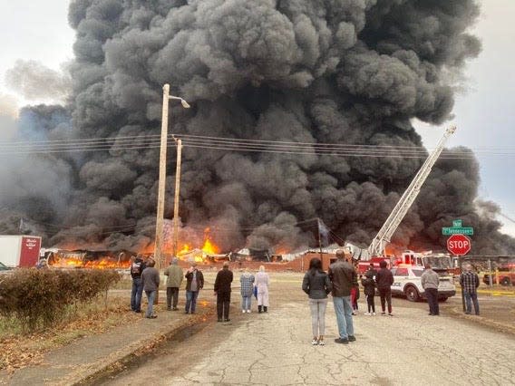 Residents watch the massive fire at a North Garvin Street warehouse on Dec. 31, 2022 in Evansville.