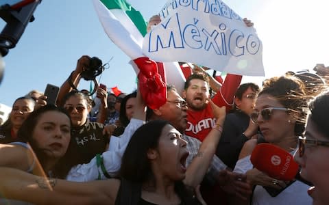 A pro-migration activist argues with demonstrators during a protest against migrants in Tijuana  - Credit:  CARLOS GARCIA RAWLINS/REUTERS