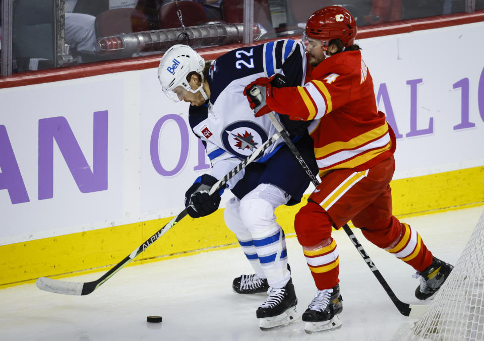 Winnipeg Jets forward Mason Appleton, left, is checked by Calgary Flames defenseman Rasmus Andersson during the second period of an NHL hockey game Saturday, Nov. 12, 2022, in Calgary, Alberta. (Jeff McIntosh/The Canadian Press via AP)