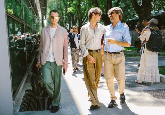 MILAN - JUNE 15: Man with black Prada pouch and beige trousers