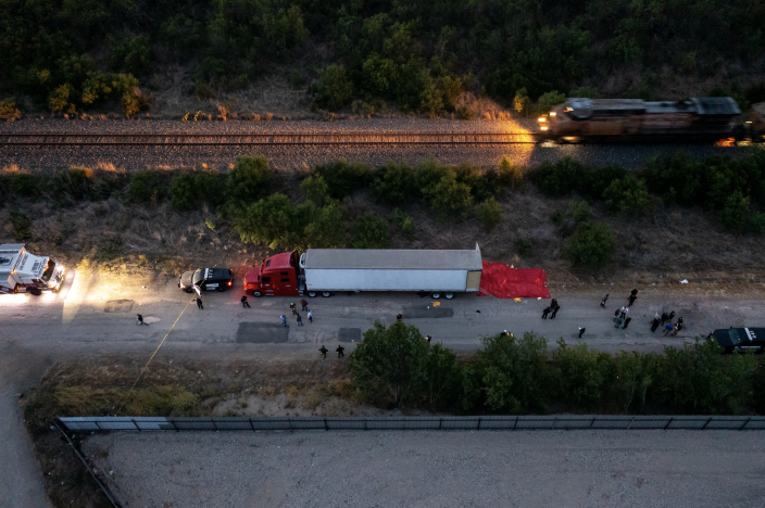 In this aerial view, members of law enforcement investigate a tractor trailer on June 27, 2022, in San Antonio, Texas. <span class="copyright">Jordan Vonderhaar/Getty Images</span>