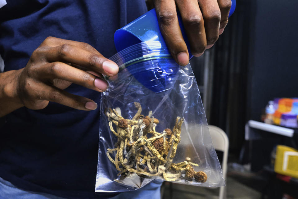 A vendor bags psilocybin mushrooms at a cannabis marketplace (Richard Vogel / AP file)