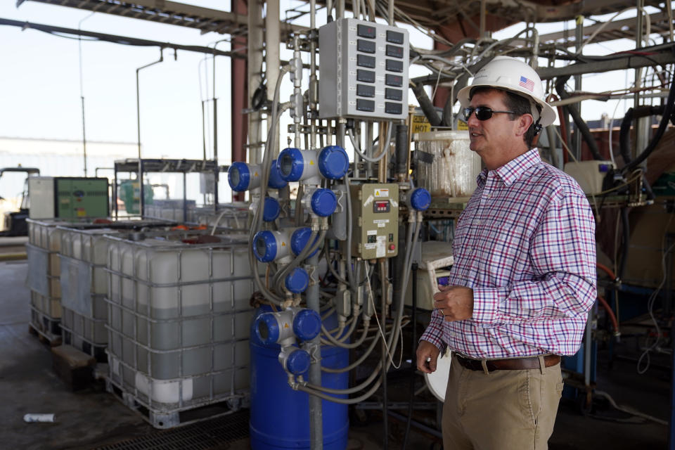 Derek Benson, chief operating officer of EnergySource Minerals, stands in front of the Iliad, integrated lithium absorption and desorption machine, used to separate brine extracted from the ground into lithium, Friday, July 16, 2021, in Calipatria, Calif. Benson says the company has extracted lithium there on a small scale since 2016 and plans to build a much larger addition for mineral extraction. (AP Photo/Marcio Jose Sanchez)