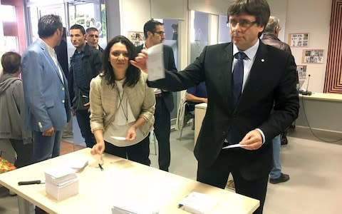 Catalan president Carles Puigdemont preparing to cast his ballot at a polling station in Cornella del Terri  - Credit: AFP