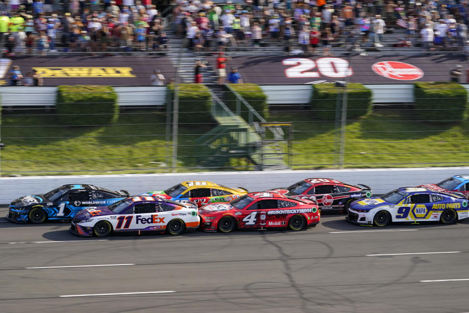 Ross Chastain (1) y Denny Hamlin (11) van a la cabeza de un grupo en una rearrancada en la prueba de NASCAR Cup Series en Pocono Raceway, con Chase Elliott (9) a la derecha, quien había quedado tercero y le fue otorgada la victoria tras la descalificación de Hamlin y Kyle Busch, el domingo 24 de julio de 2022, en Long Pond, Pa. (AP Foto/Matt Slocum)