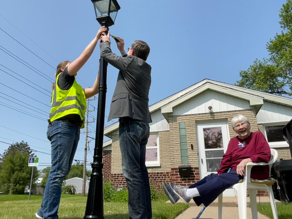 93-year-old homeowner Roana Fenzau, right, has plenty of fun watching South Bend Mayor James Mueller and a city engineer install a solar-powered lamppost in her front yard. She's lived in her home in the Far Northwest neighborhood since 1970.