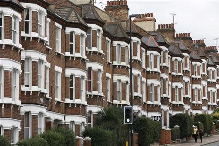 Pedestrian walk past houses in London October 7, 2013. The government will launch their "Help to Buy" scheme on Tuesday, unveiling details of 95% mortgages which will be available to existing homeowners and first-time buyers. REUTERS/Stefan Wermuth