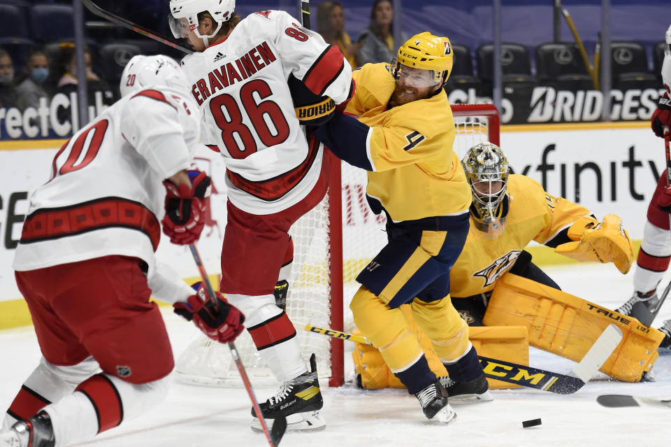 Nashville Predators defenseman Ryan Ellis (4) shoves Carolina Hurricanes left wing Teuvo Teravainen (86) away from the puck during the first period of an NHL hockey game Saturday, May 8, 2021, in Nashville, Tenn. (AP Photo/Mark Zaleski)