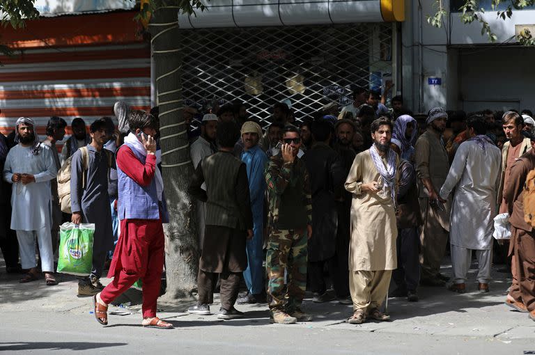 Los afganos esperan en largas filas durante horas para retirar dinero, cerca del Kabul Bank, en Kabul, Afganistán