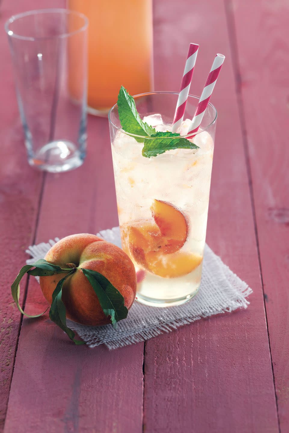 ginger peach soda in a glass with ice peach slices and fresh mint leaves for garnish