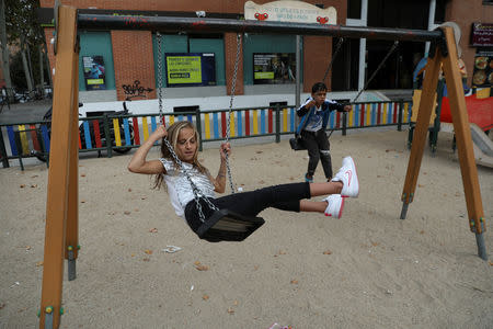 David Stan, 7, and his sister Beatriz, 9, play at a playground outside their new apartment after being relocated from El Gallinero shanty town in Madrid, Spain, September 26, 2018. REUTERS/Susana Vera