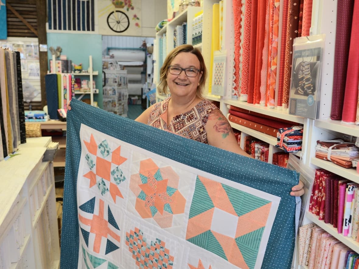 Michaelanne Hathaway is the owner of Stache Fabric and Notions located at 213 King St. in downtown London, Ont.'s historic Novacks building. She's rallying her community of customers to collectively sew quilts for My Sisters' Place in London. (Michelle Both/CBC - image credit)