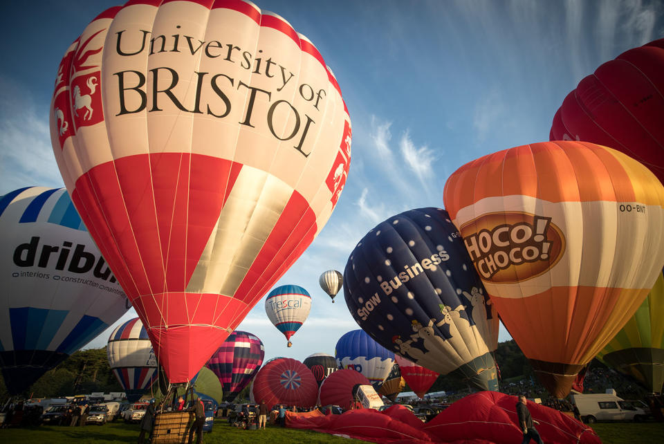 <p>Hot air balloons are inflated and take to the skies as they participate in the mass assent at sunrise in the main arena on the second day of the Bristol International Balloon Fiesta on August 11, 2017 in Bristol, England. (Photo: Matt Cardy/Getty Images) </p>