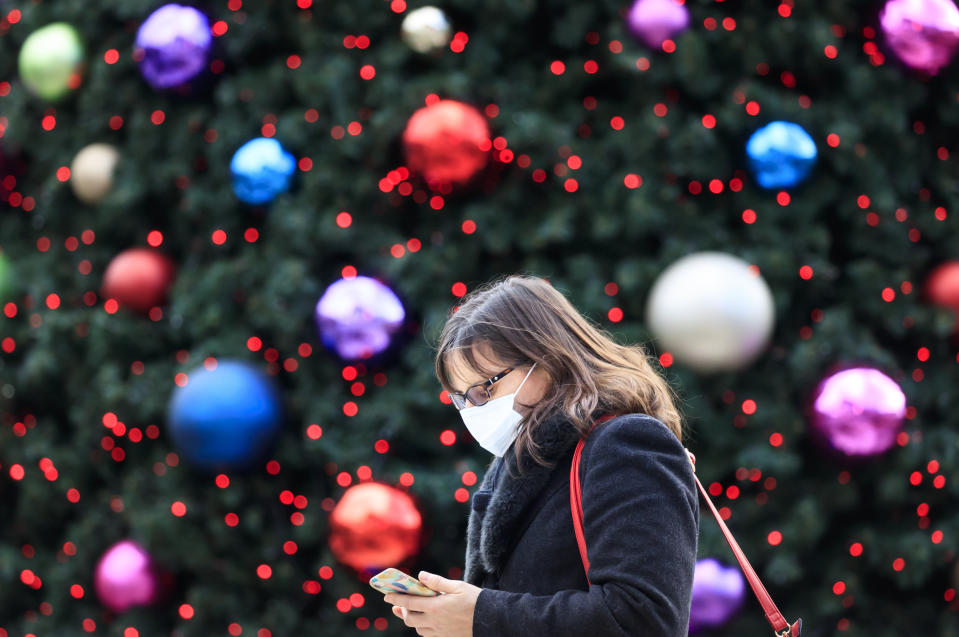 A woman walks past a Christmas tree in Trinity Leeds shopping centre in Leeds, Yorkshire, as England continues a four week national lockdown to curb the spread of coronavirus.