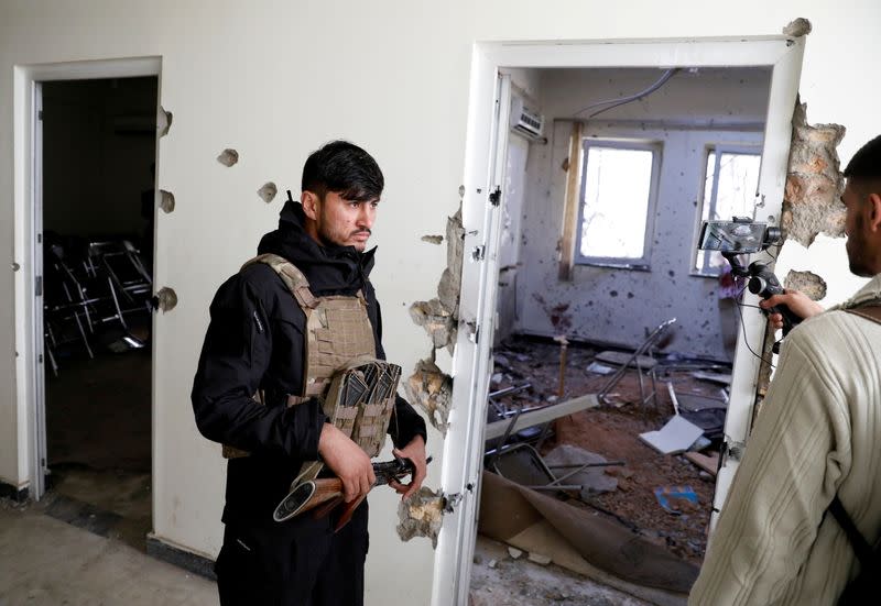 An Afghan policeman inspects the site after yesterday's attack at the university of Kabul