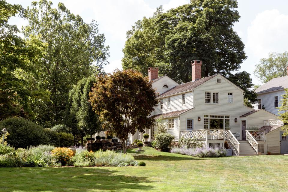 Stubbs & Wootton founder Percy Steinhart’s home in Litchfield, Connecticut, is around 3,000 square feet and was built in stages; the earliest section dates to 1784. An exterior view shows the lush gardens and, under the trees, a charming stone terrace.