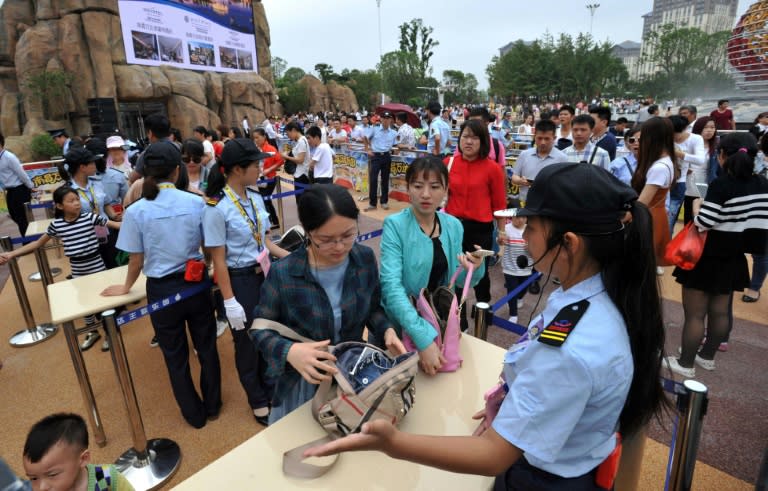 Visitors check through security at Wanda City on the day the theme park opened its doors on May 28, 2016