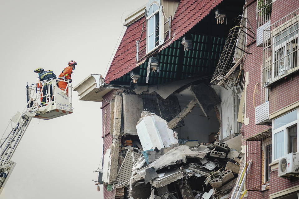 A fireman looks into the partially collapsed section of a building in China's Tianjin Municipality Tuesday, July 19, 2022. A gas explosion left some missing and others injured. (Chinatopix Via AP) CHINA OUT