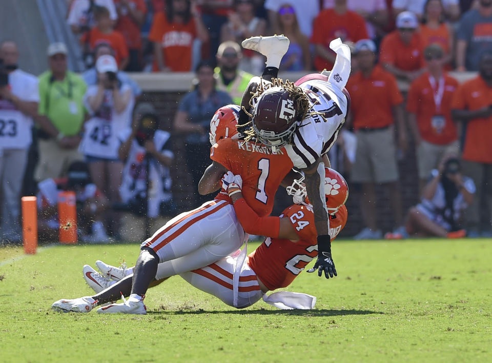 Texas A&M's Kendrick Rogers, top, is tackled by Clemson's Derion Kendrick (1) and Nolan Turner during the first half of an NCAA college football game Saturday, Sept. 7, 2019, in Clemson, S.C. (AP Photo/Richard Shiro)