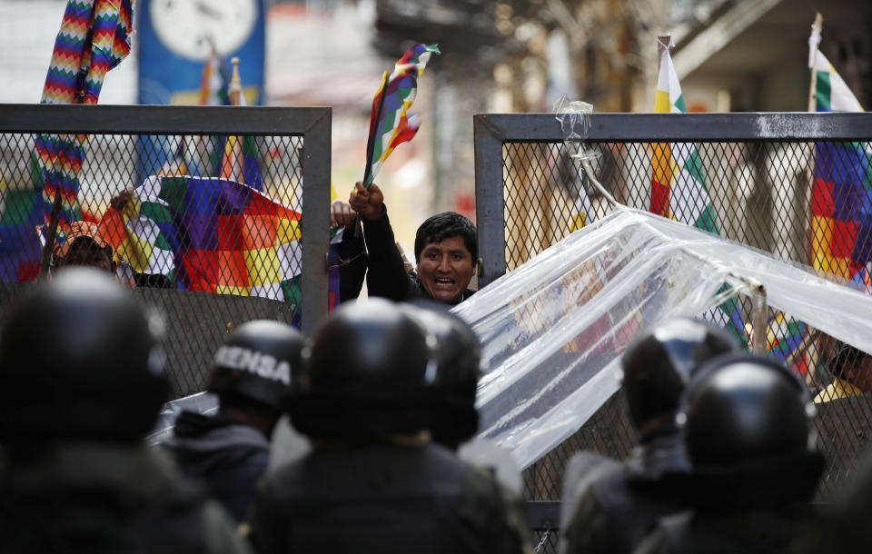 Police block supporters of former President Evo Morales from entering the area of Congress in La Paz, Bolivia, Tuesday, Nov. 12, 2019. Morales, who transformed Bolivia as its first indigenous president, flew to exile in Mexico on Tuesday after weeks of violent protests, leaving behind a confused power vacuum in the Andean nation. (AP Photo/Natacha Pisarenko)
