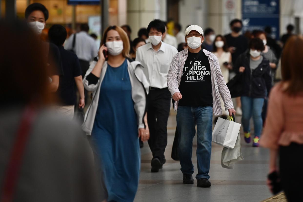 People wearing face masks walk in a train station amid the COVID-19 coronavirus outbreak in Kawasaki on May 11, 2020. (Photo by CHARLY TRIBALLEAU / AFP) (Photo by CHARLY TRIBALLEAU/AFP via Getty Images)