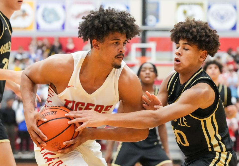 Fishers Tigers forward Keenan Garner (23) rushes up the court against Noblesville Millers guard Baron Walker (30) on Friday, Dec. 1, 2023, during the game at Fishers High School in Fishers. The Fishers Tigers defeated the Noblesville Millers, 66-59.