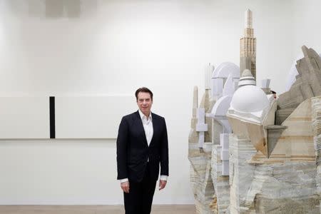 David Maupin, Founder and gallery director, Lehmann Maupin Gallery, poses next to "Library V-II" (2015-2018) (R) of Chinese artist Liu Wei and "Untitled (White, Black, Beveled)" 2018 of U.S. artist Mary Corse during the Art Basel in Basel, Switzerland, June 13, 2018. REUTERS/Moritz Hager