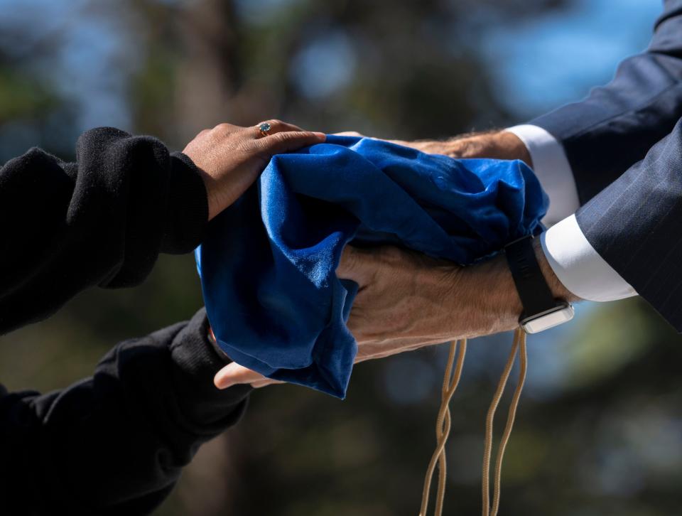 A volunteer passes on unclaimed remains to Chas Schaffernoth to be buried Monday, Sept. 26, 2022, at Oaklawn Memorial Gardens in Fishers.